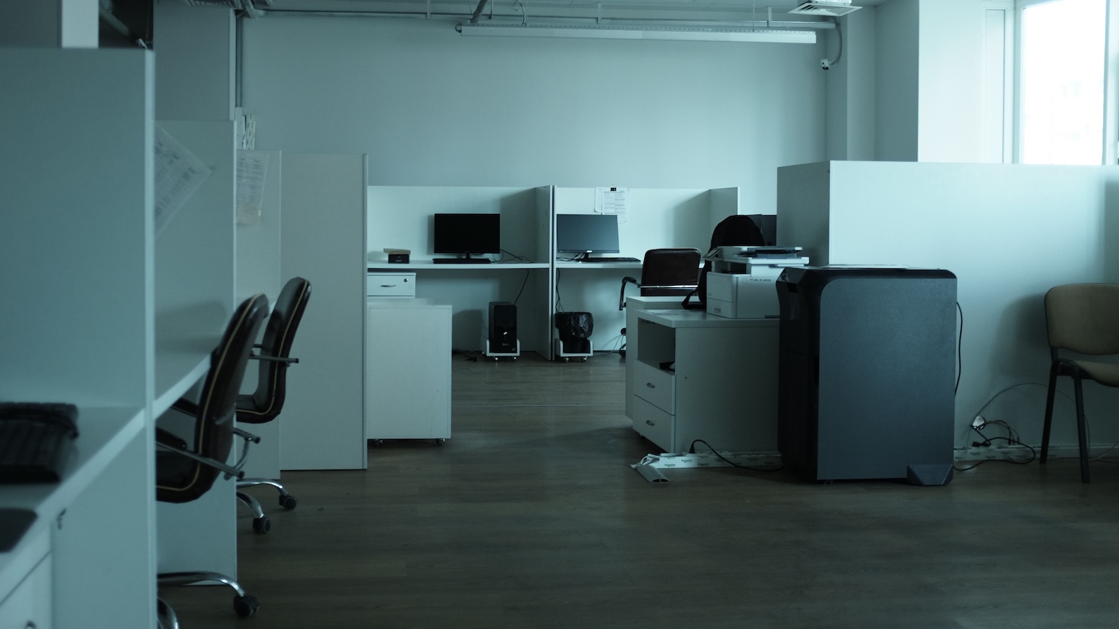 Empty corporate office with unoccupied cubicles and workstations, reflecting a quiet and largely vacant workplace.