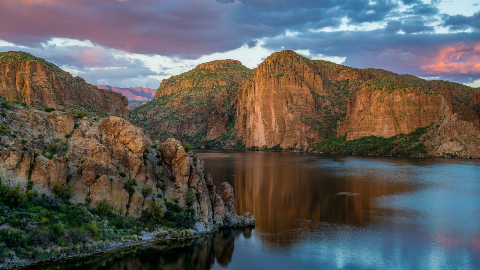 Canyon-Lake Canyon Lake surrounded by towering red-rock cliffs beneath a dramatic evening sky in the Superstition Mountains.