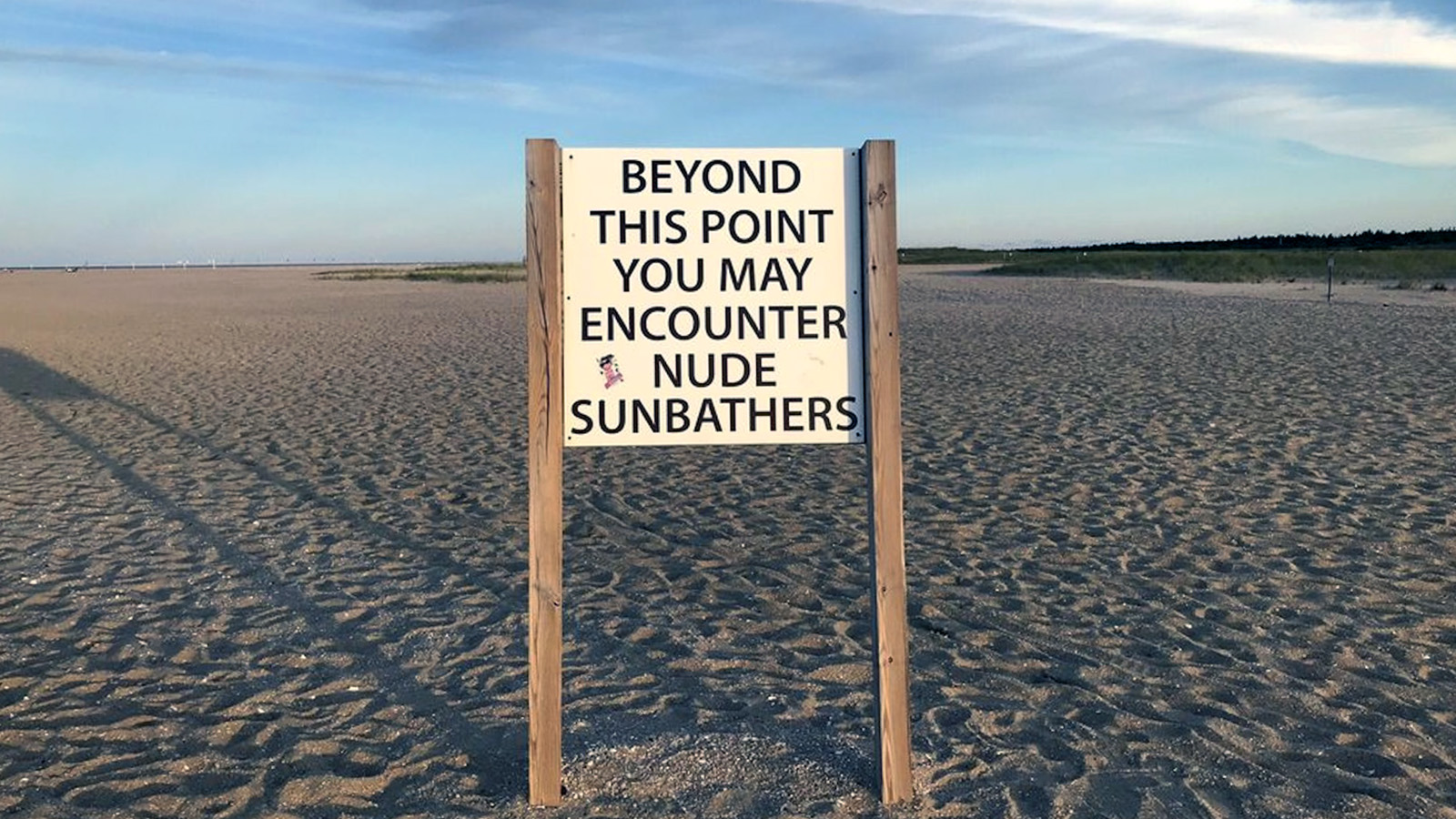 A warning sign at the entrance of Gunnison Beach reads: "Beyond this point you may encounter nude sunbathers."