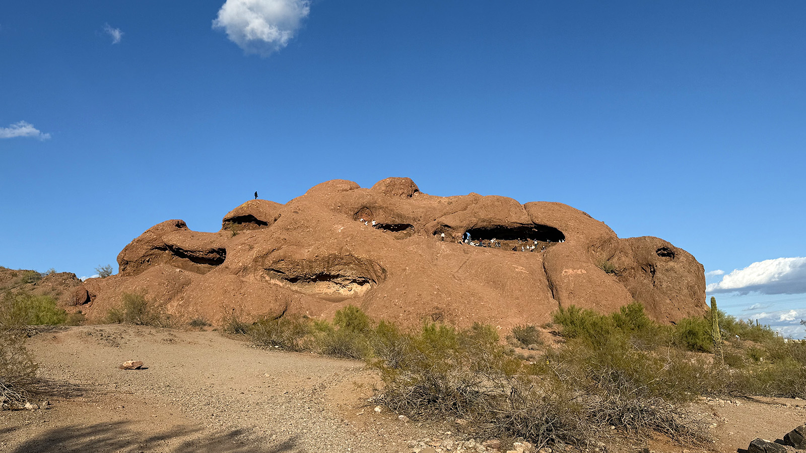 papago Red sandstone formations at Papago Park beneath a clear blue Arizona sky, with visitors visible near Hole in the Rock.