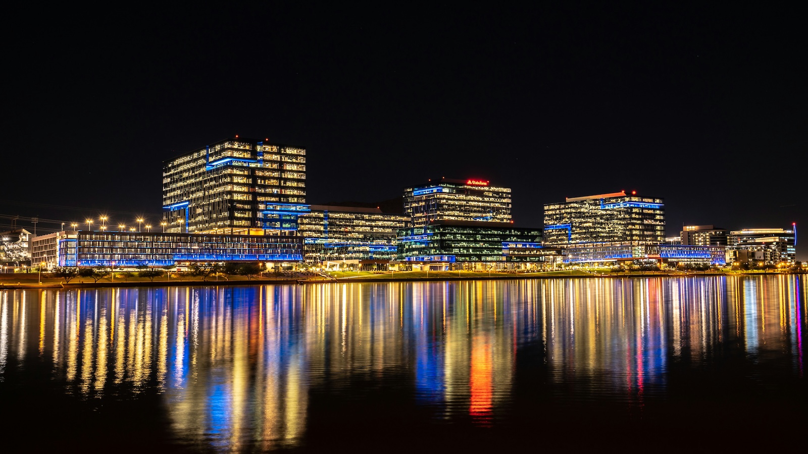tempe Downtown Tempe illuminated at night, with city lights reflecting across the calm water of Tempe Town Lake.
