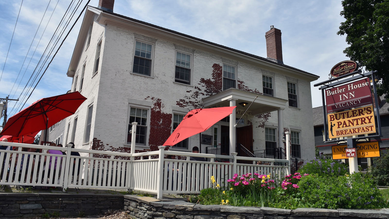 The historic white Butler House in Stowe with red patio umbrellas and a sign for Butler’s Pantry breakfast restaurant.